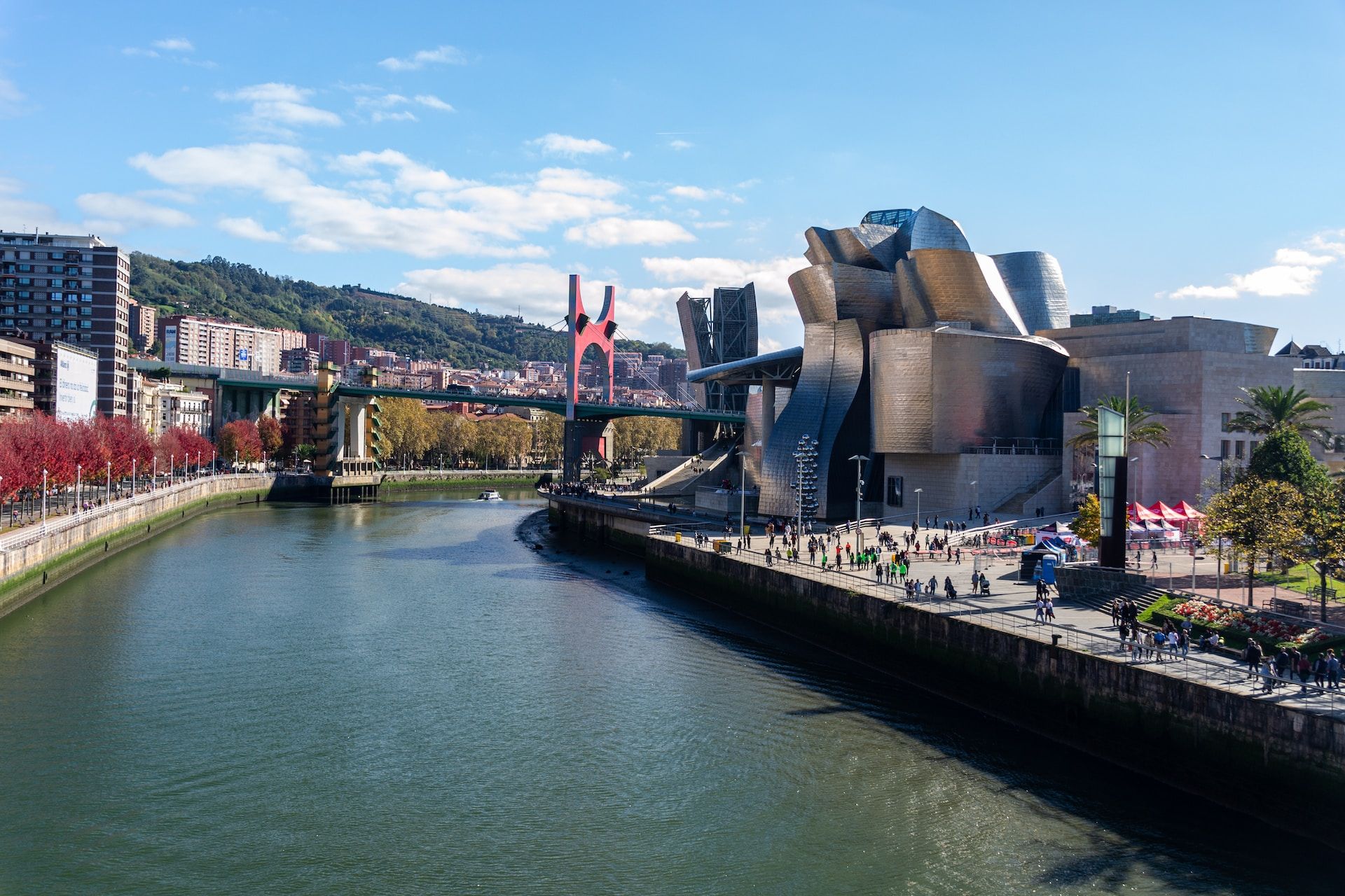 A river running through a city next to a bridge photo Bilbao